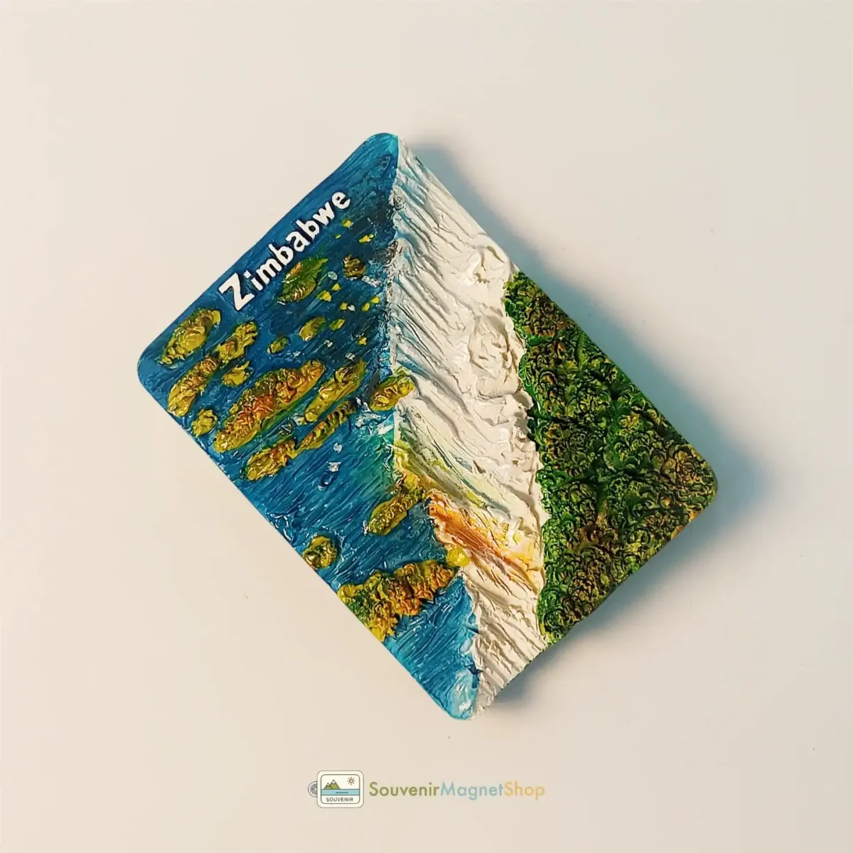 Left side view of the Zimbabwe Victoria Falls fridge magnet, a colorful souvenir.