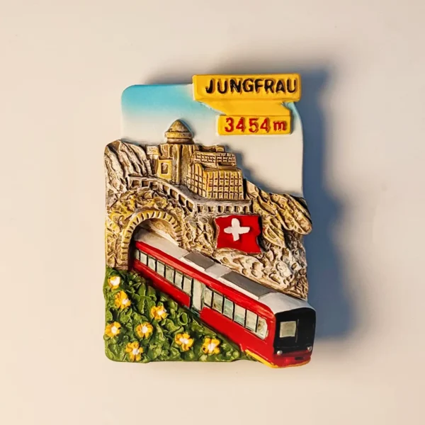 Front view of a 3D hand-painted resin Jungfraujoch High Mountain Railway fridge magnet, featuring the red train, mountain peak, and Swiss flag.