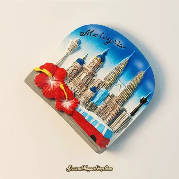 Angled view of a Malaysia travel gift magnet with 3D Petronas Twin Towers, KL Tower, and the national flower, the hibiscus, perfect for collectors.