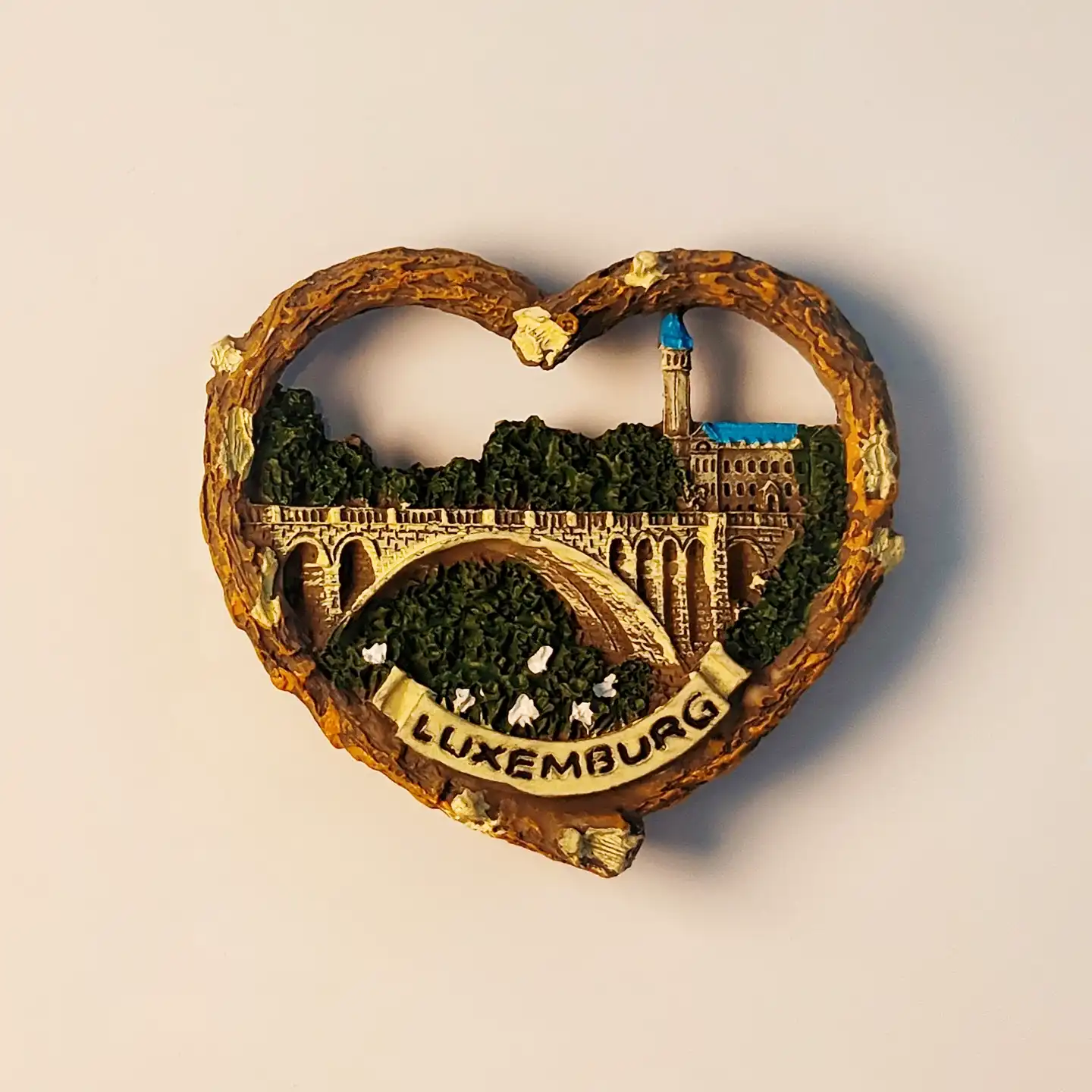 Front view of heart-shaped Luxembourg City fridge magnet featuring Adolphe Bridge, Notre-Dame Cathedral, and "Luxemburg" banner.