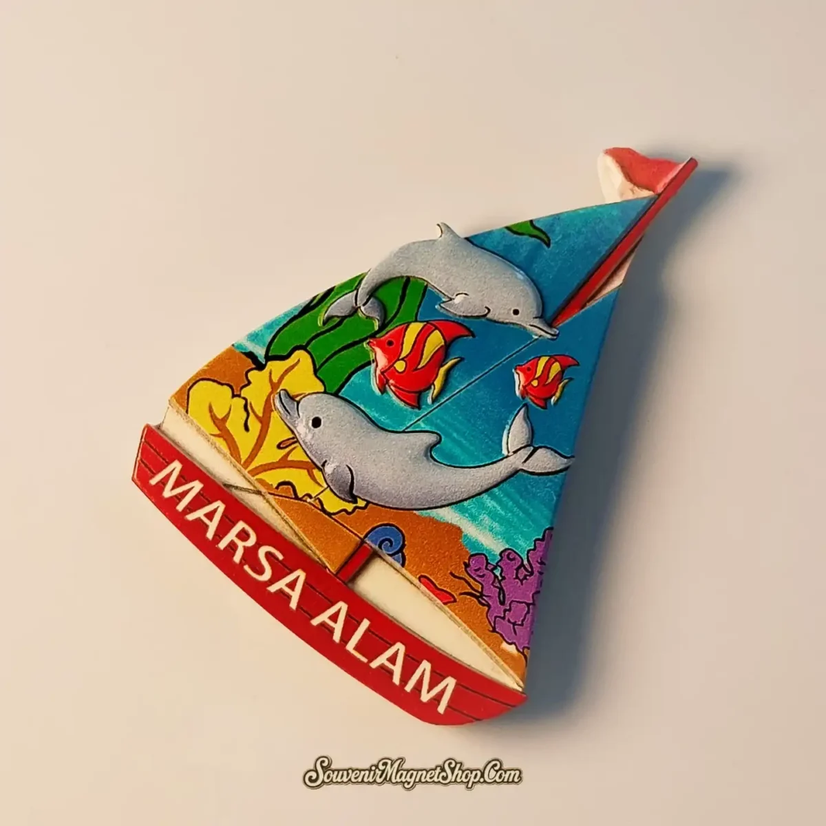 Close-up detail of Marsa Alam sailboat souvenir magnet highlighting hand-painted marine life color craftsmanship
