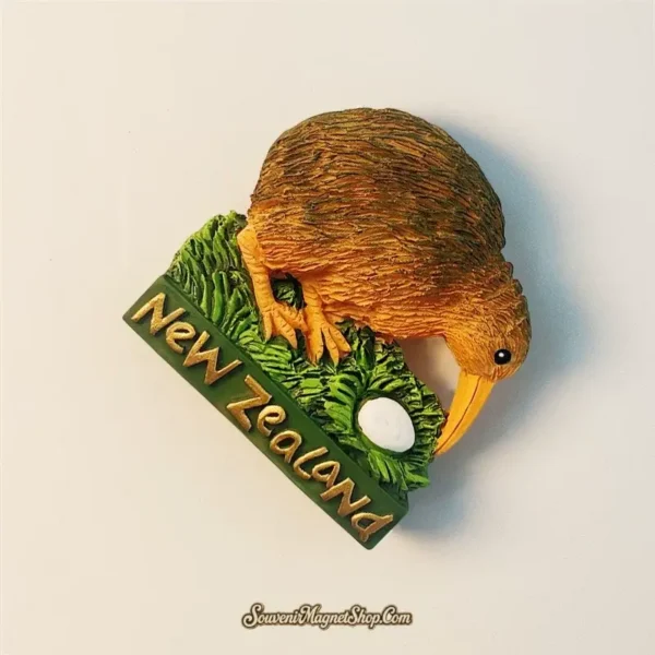 Side angle of the New Zealand Kiwi bird magnet with raised golden New Zealand text and nesting details.