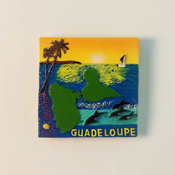 Front view of a Guadeloupe sunset seascape fridge magnet featuring palm trees, dolphins, sailboat, and the island outline.