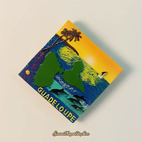 Detailed view of a Guadeloupe travel gift magnet showing a tropical sunset and ocean scene.