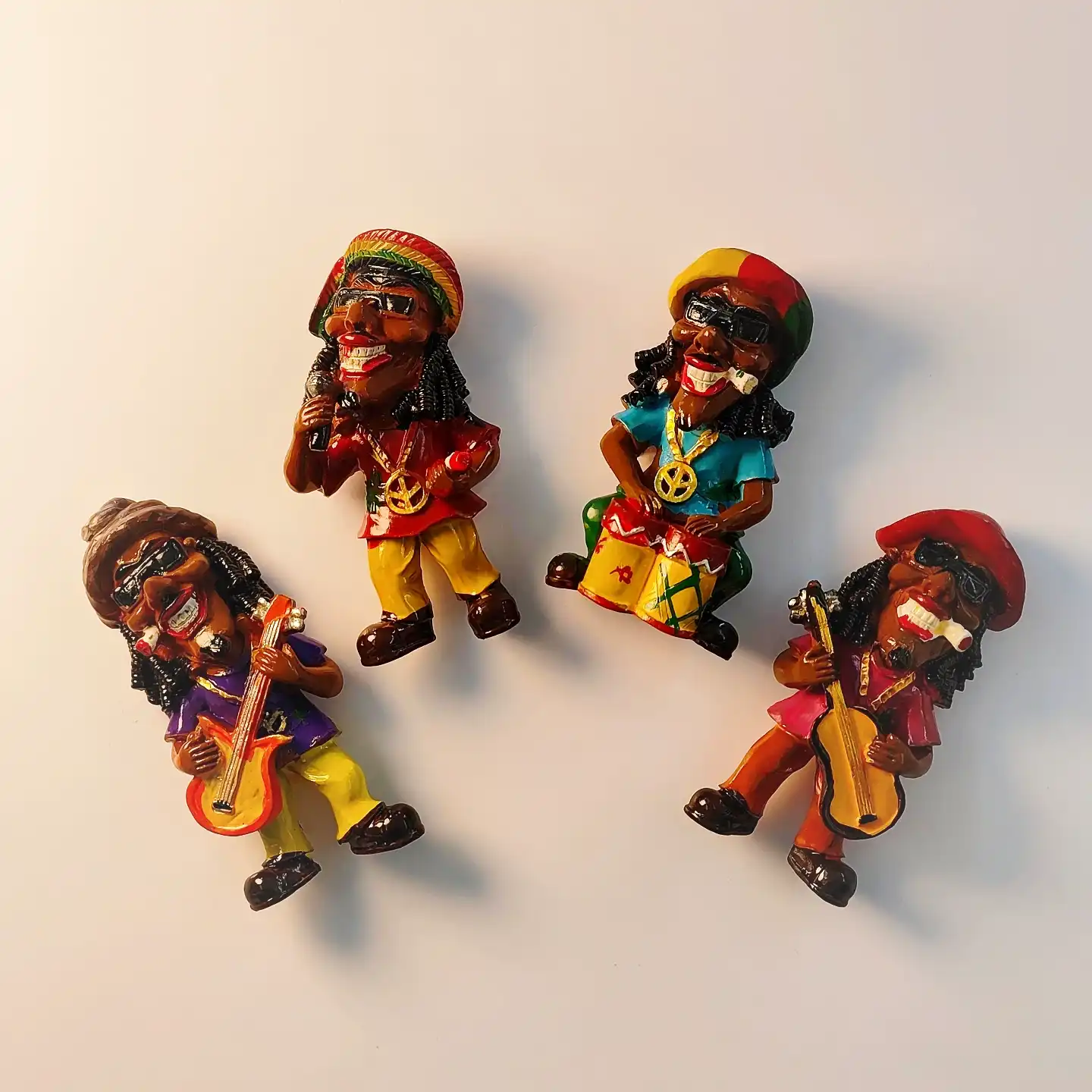 Hand-painted Jamaica reggae band fridge magnet set showing vocalist, guitarist, and drummer figurines.