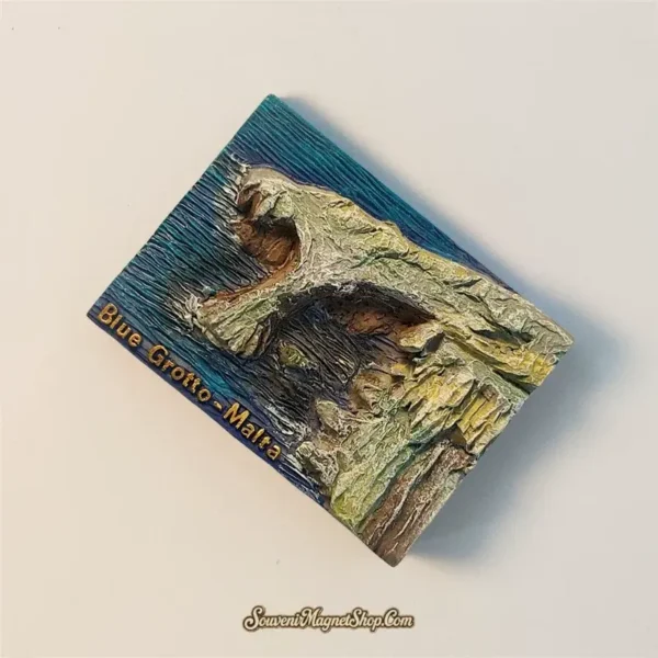 Overhead view of a Malta Blue Grotto travel gift magnet, displaying its unique shape and hand-painted details.