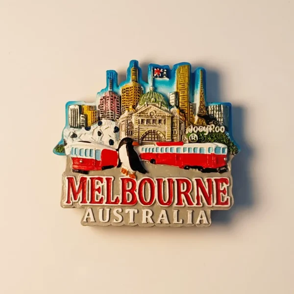 Front view of a colorful hand-painted 3D Melbourne cityscape fridge magnet with Flinders Street Station, tram, and a penguin.
