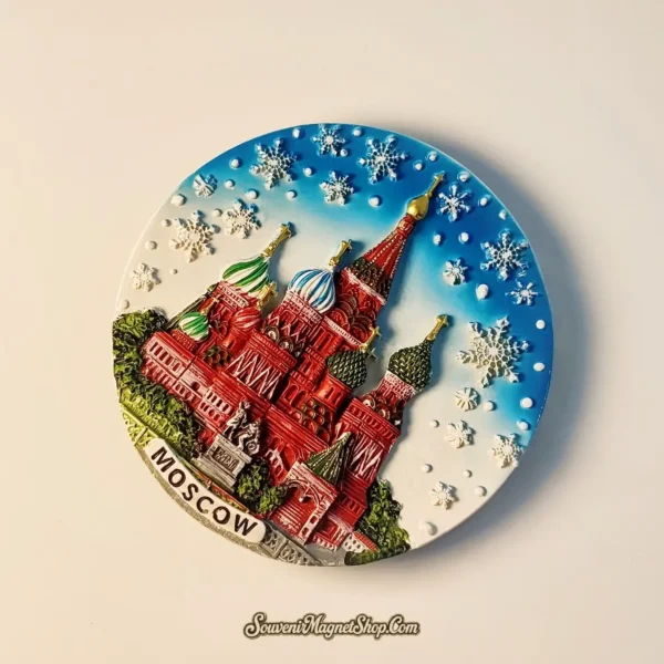 An artistic travel gift magnet of Moscow with embossed snowflakes and the iconic Saint Basil's Cathedral in a circular plate design.