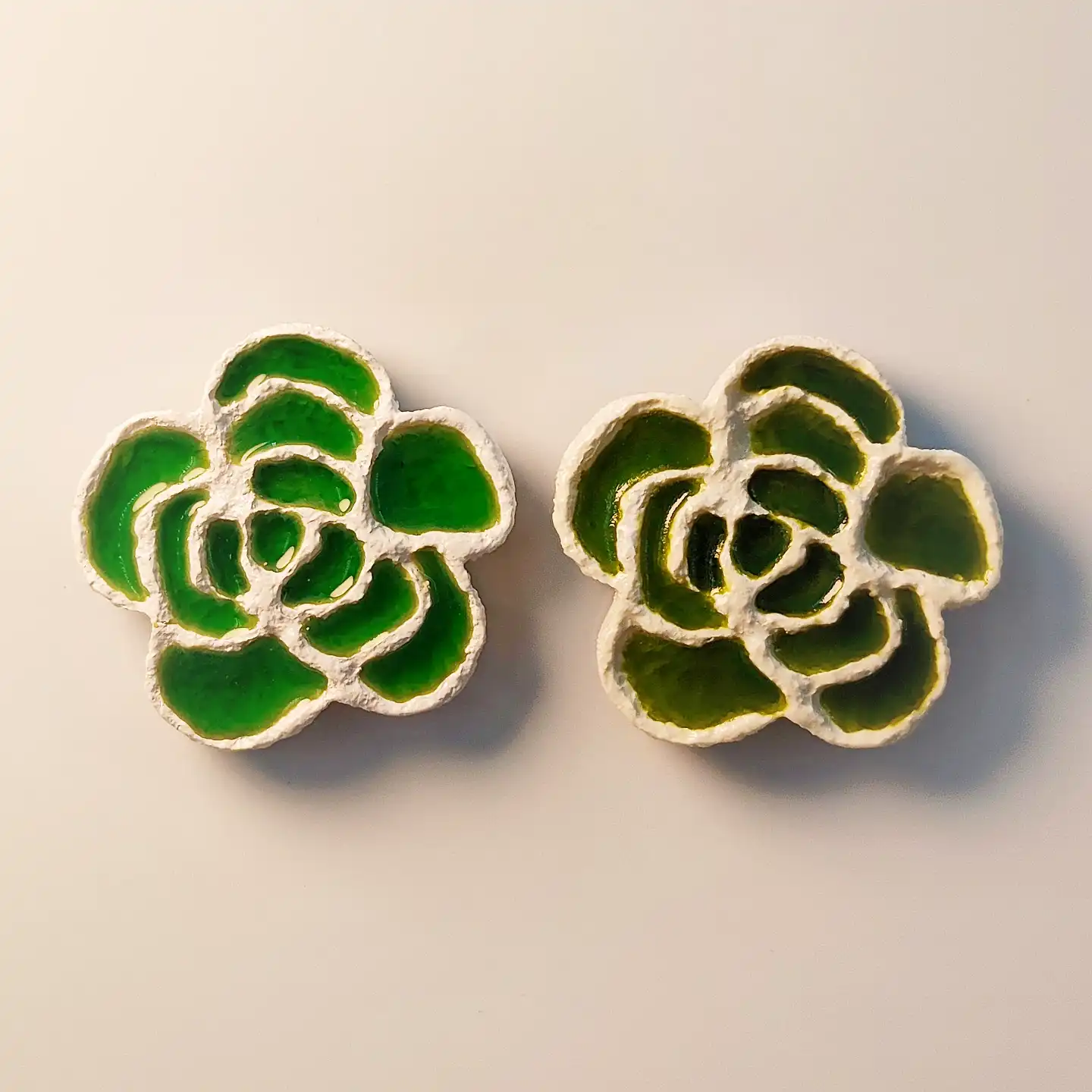 A pair of rose-shaped fridge magnets inspired by Qinghai Emerald Salt Lake with translucent green resin and white salt-like texture.
