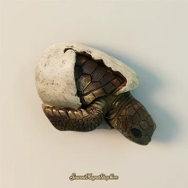Unique travel gift magnet featuring a lifelike baby sea turtle breaking free from its egg, ideal for nature lovers and collectors.