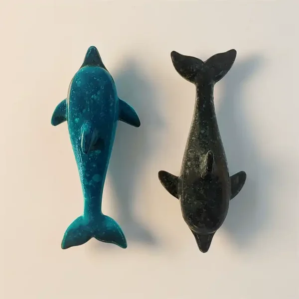 Close-up front view of two Semporna dolphin fridge magnets, one in vibrant blue and the other in dark, showcasing their detailed, sleek designs.
