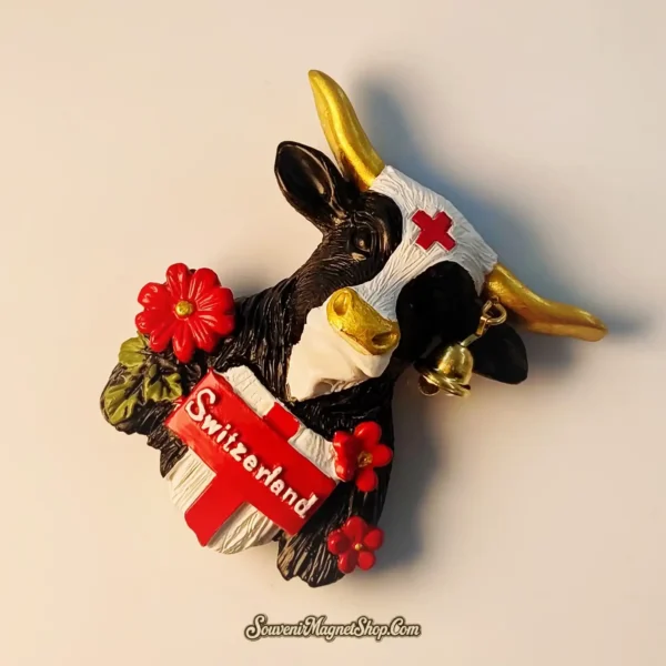 Angled view of a vibrant Switzerland Alpine Bell Cow magnet, an ideal travel gift showcasing Swiss charm and the "Switzerland" banner.