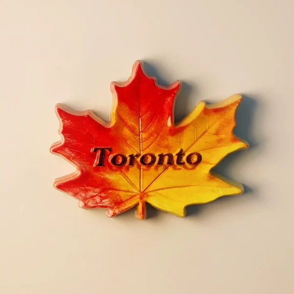 Front view of a vibrant red and yellow Toronto Maple Leaf 3D lettering fridge magnet.