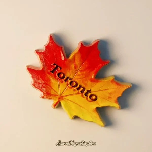 Thoughtful travel gift: a hand-painted Toronto Maple Leaf fridge magnet, perfect for collectors.