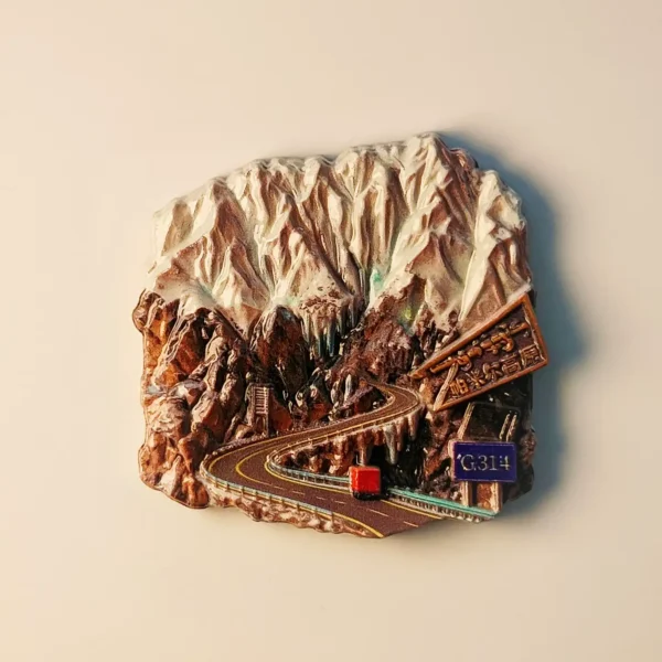 Front view of a detailed 3D fridge magnet depicting China Xinjiang Pamir Highway G314 National Road with snowy mountains and a red truck.