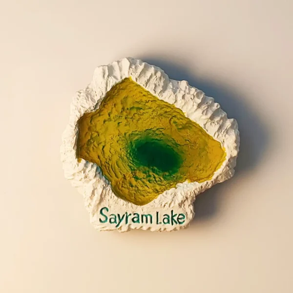 A high-angle front view of a 3D hand-painted Sayram Lake fridge magnet featuring vibrant green and yellow lake waters surrounded by white rocky edges.