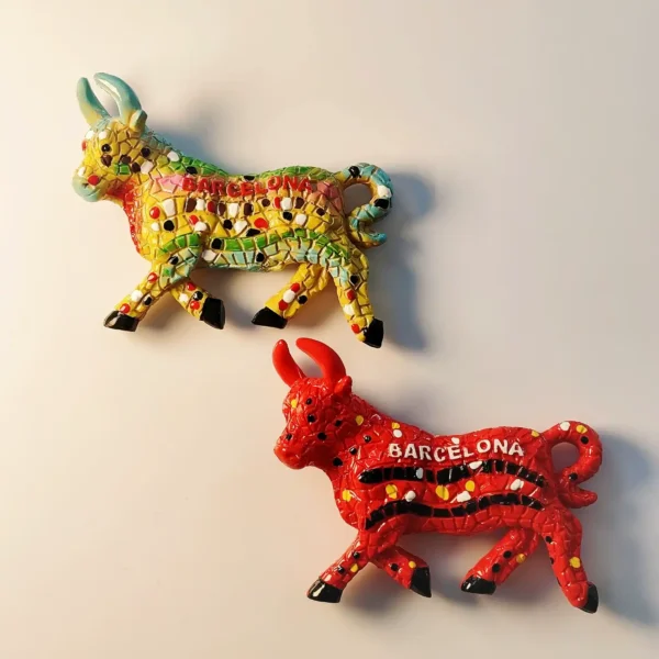 A pair of 3D mosaic bull fridge magnets from Barcelona, Spain, featuring vibrant red and yellow hand-painted tile designs.