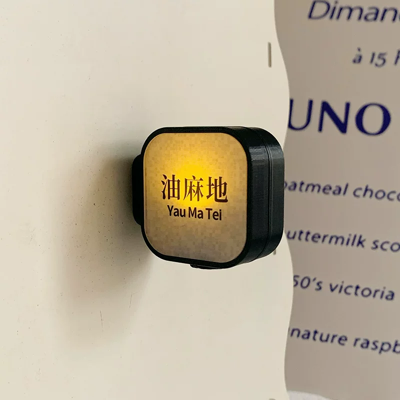 Light-up Yau Ma Tei MTR station sign fridge magnet with warm amber glow on white surface