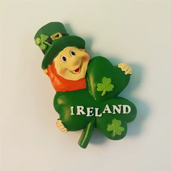 Hand-painted Irish Leprechaun holding a shamrock fridge magnet with "IRELAND" written on it, front view.
