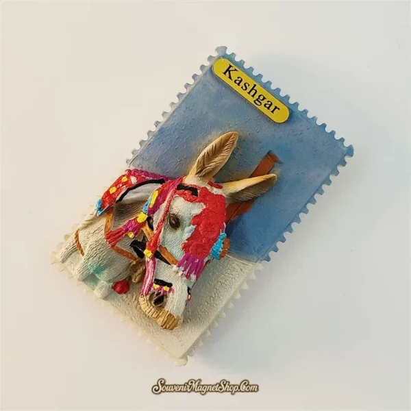 Angled view of Kashgar donkey fridge magnet showing 3D relief depth of decorated donkey head on postage stamp shaped base