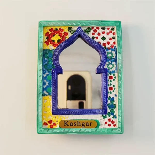 Front view of Kashgar souvenir fridge magnet with teal green Greek key border, colorful floral patchwork background and blue arch mirror