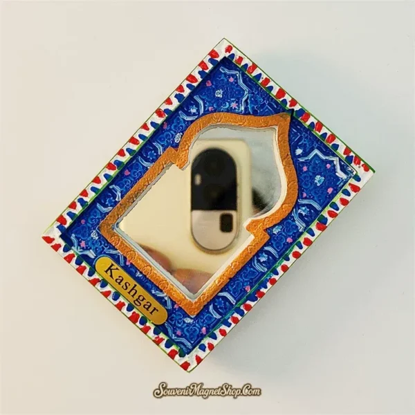 Angled view of Kashgar arch mirror fridge magnet showing blue geometric arabesque border and red white serrated edge