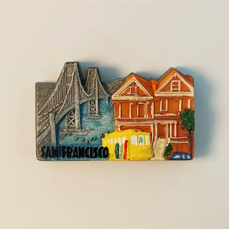 San Francisco fridge magnet front view featuring Golden Gate Bridge silver relief, yellow cable car, and Painted Ladies Victorian houses
