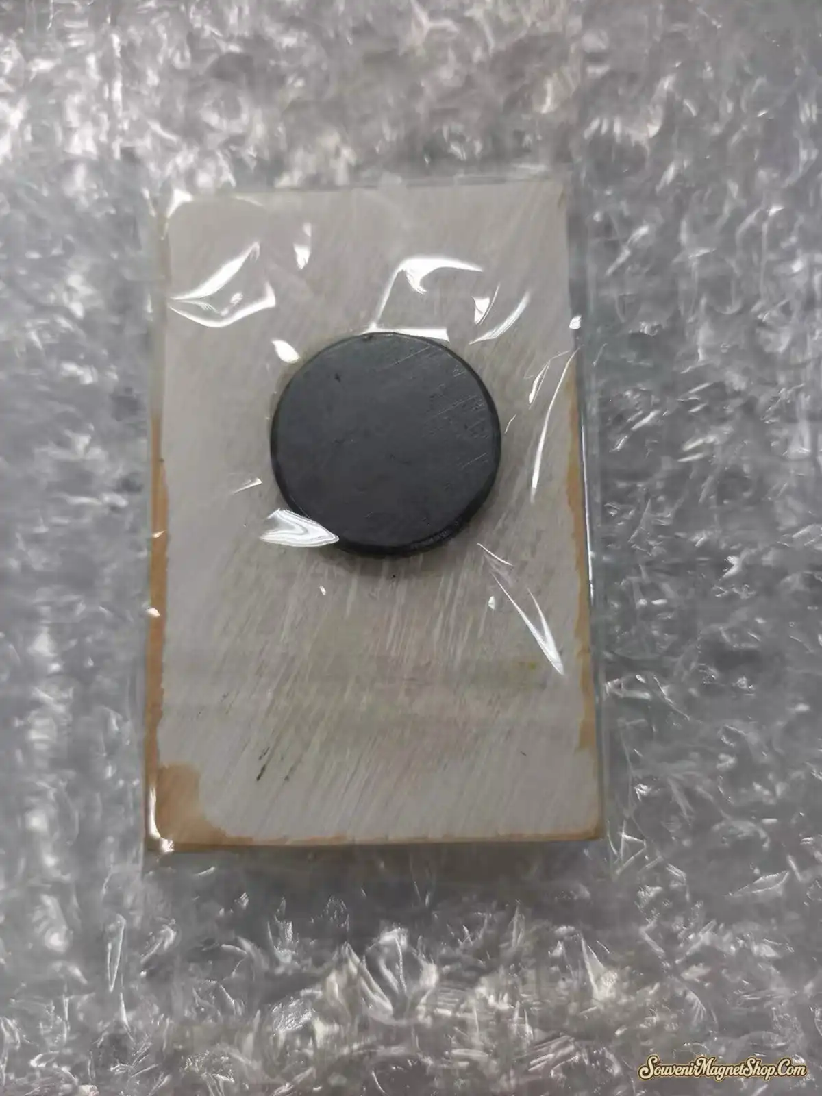 Customer review photo of Sydney Australia fridge magnet back showing round ferrite magnet in bubble wrap packaging