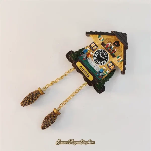 Austria Alpine feast cuckoo clock souvenir magnet angled view showing 3D dancers, beer hall scene and hanging pinecone chains