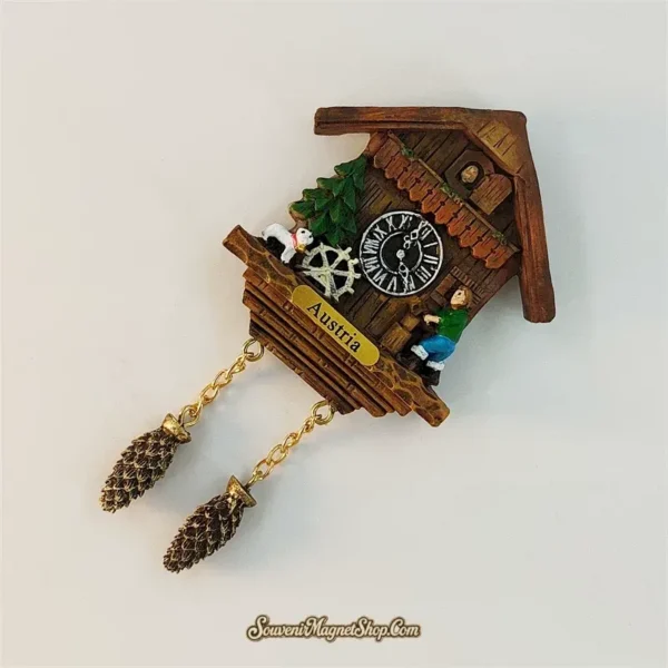 Austria Alpine waterwheel cuckoo clock souvenir magnet angled view showing chalet, villager, goat and hanging pinecone chains
