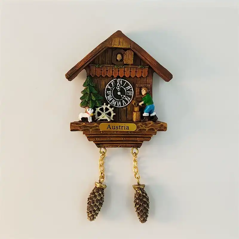 austria-waterwheel-cuckoo-clock-fridge-magnet-front Austria waterwheel cuckoo clock fridge magnet front view with Alpine chalet, villager pumping water, small goat and pinecone weights