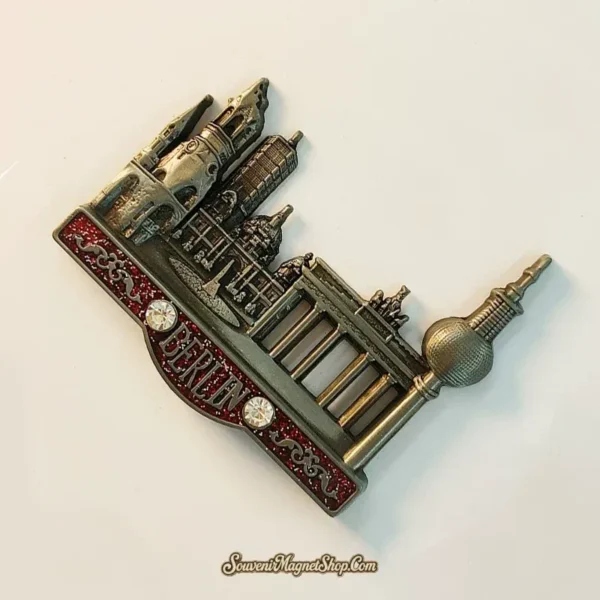 Left angle of Berlin skyline metal souvenir magnet showing raised landmark relief and rhinestone accents