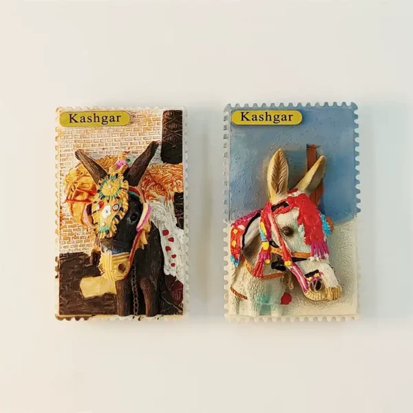 Front view of China Kashgar souvenir fridge magnet set with brown and white decorated donkeys in postage stamp style with Kashgar gold labels