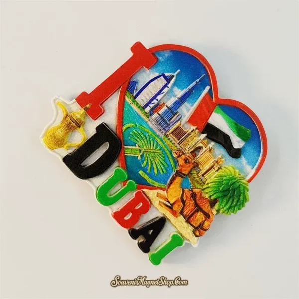 Angle view of the I love Dubai heart UAE souvenir magnet showing 3D landmark relief and chunky "I DUBAI" lettering in flag colors