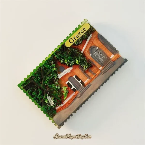 Greece ivy village guesthouse souvenir fridge magnet angled left view showing 3D depth of stamp-shaped resin magnet terracotta brick arched doors green ivy canopy and perforated stamp edge