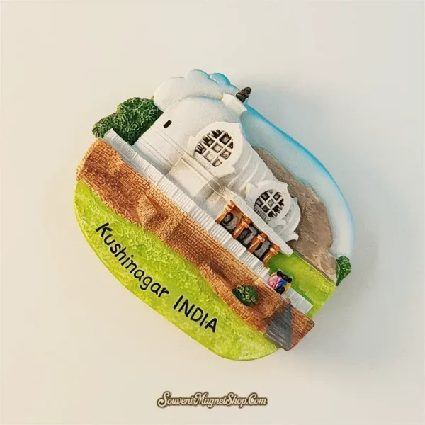 India Kushinagar souvenir fridge magnet angled top view showing 3D sculpted Mahaparinirvana Temple stupa, decorative round windows, green landscape and ornate architectural details