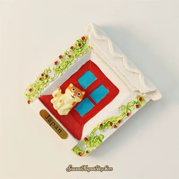 Angled left view of Japan cat cottage souvenir magnet showing 3D depth with ivy vines and Japan label