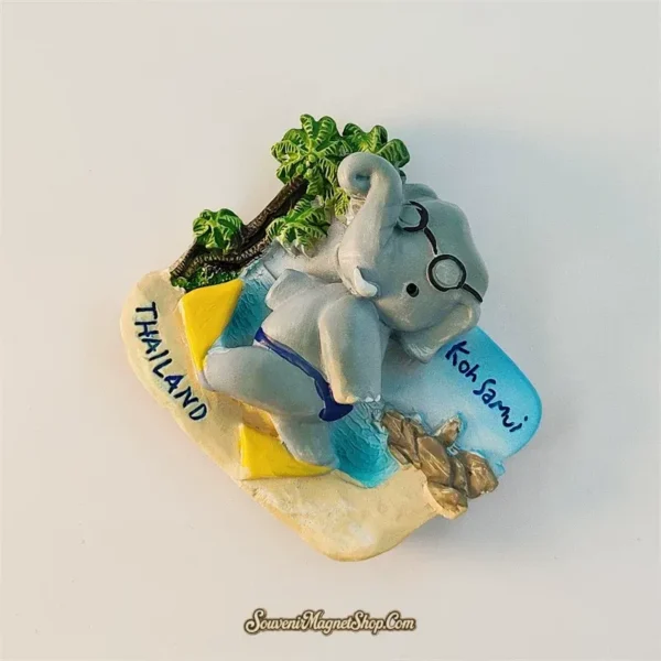 Top-down angled view of Koh Samui snorkeling elephant souvenir magnet with palm trees and yellow towel