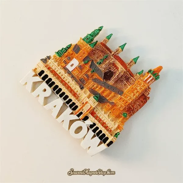 Angled view of a Krakow Main Market Square souvenir magnet with warm-toned architecture and raised city lettering