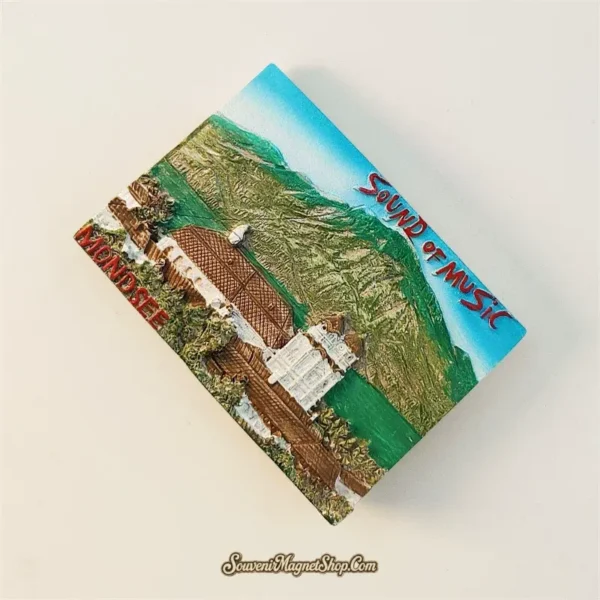 Angled view of 3D hand-painted Mondsee basilica souvenir magnet showing raised alpine relief