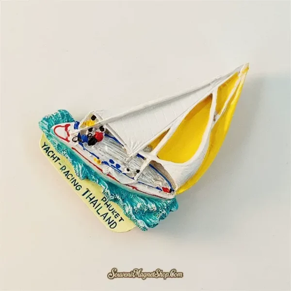 Angled view showing 3D depth of Phuket yacht racing magnet with hand-painted sailboat and wave texture