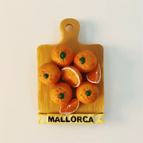 Spain Mallorca fridge magnet front view shaped like a wooden cutting board with 3D sculpted oranges including halved orange cross-section and MALLORCA ribbon banner