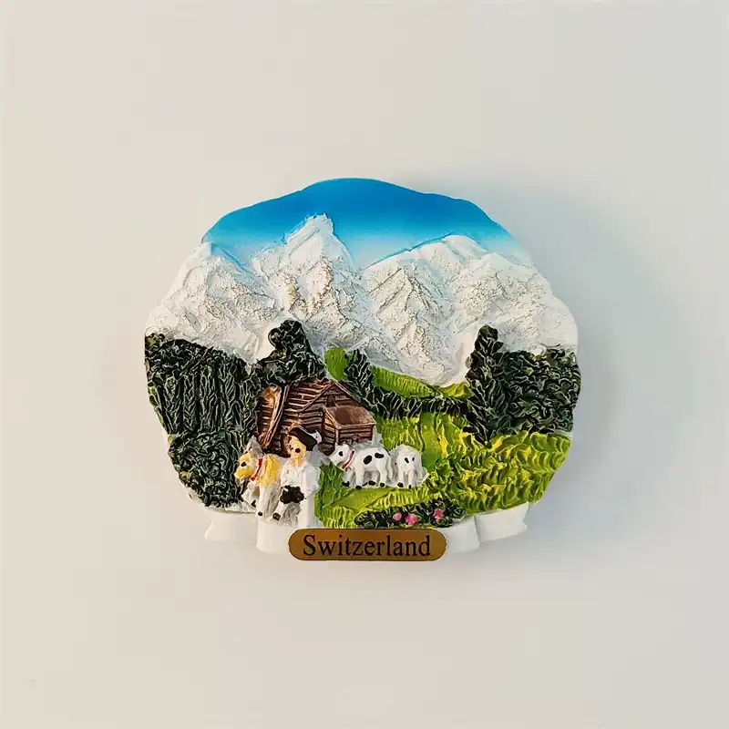 switzerland-jungfrau-alpine-fridge-magnet-front Front view of Switzerland Jungfrau Alpine fridge magnet with snow-capped mountains, green meadow, chalet and grazing dairy cows