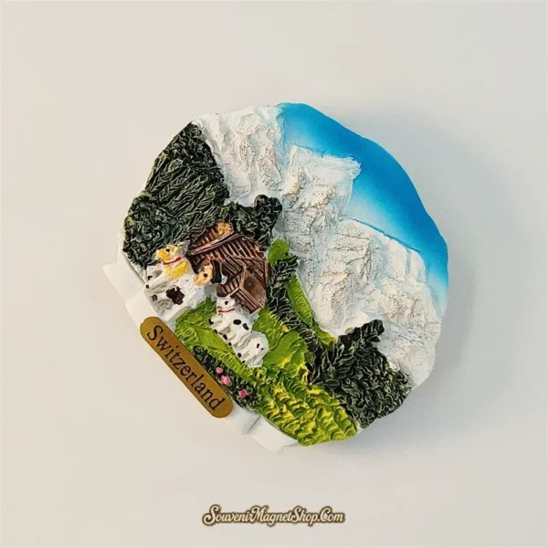Left-angle view of Switzerland Jungfrau souvenir magnet showing snow peaks and Alpine meadow 3D relief detail
