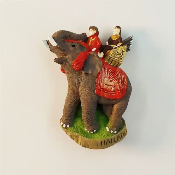 Thailand elephant riding fridge magnet front view with mahout in red traditional Thai costume and gold ceremonial saddle