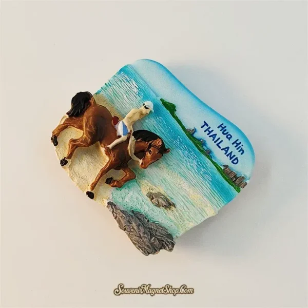 Angled left view of Hua Hin beach horse riding souvenir magnet showing 3D depth and ocean scene