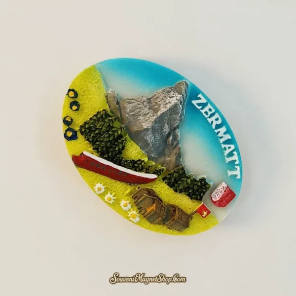 Angle view of the Zermatt Matterhorn souvenir magnet showing the sculpted peak rising in 3D relief above the Alpine meadow scene