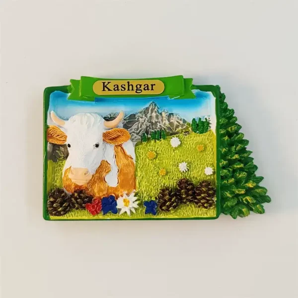 Front view of Kashgar fridge magnet with 3D hand-painted cow on green grassland and snowy peaks