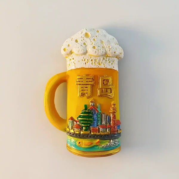 China Qingdao beer mug fridge magnet front view with foamy head, gold Qingdao characters and 3D skyline of red-roofed landmarks