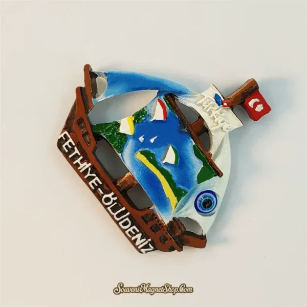 Angled view of Fethiye-Ölüdeniz sailing boat souvenir magnet showing 3D wooden hull and painted sail